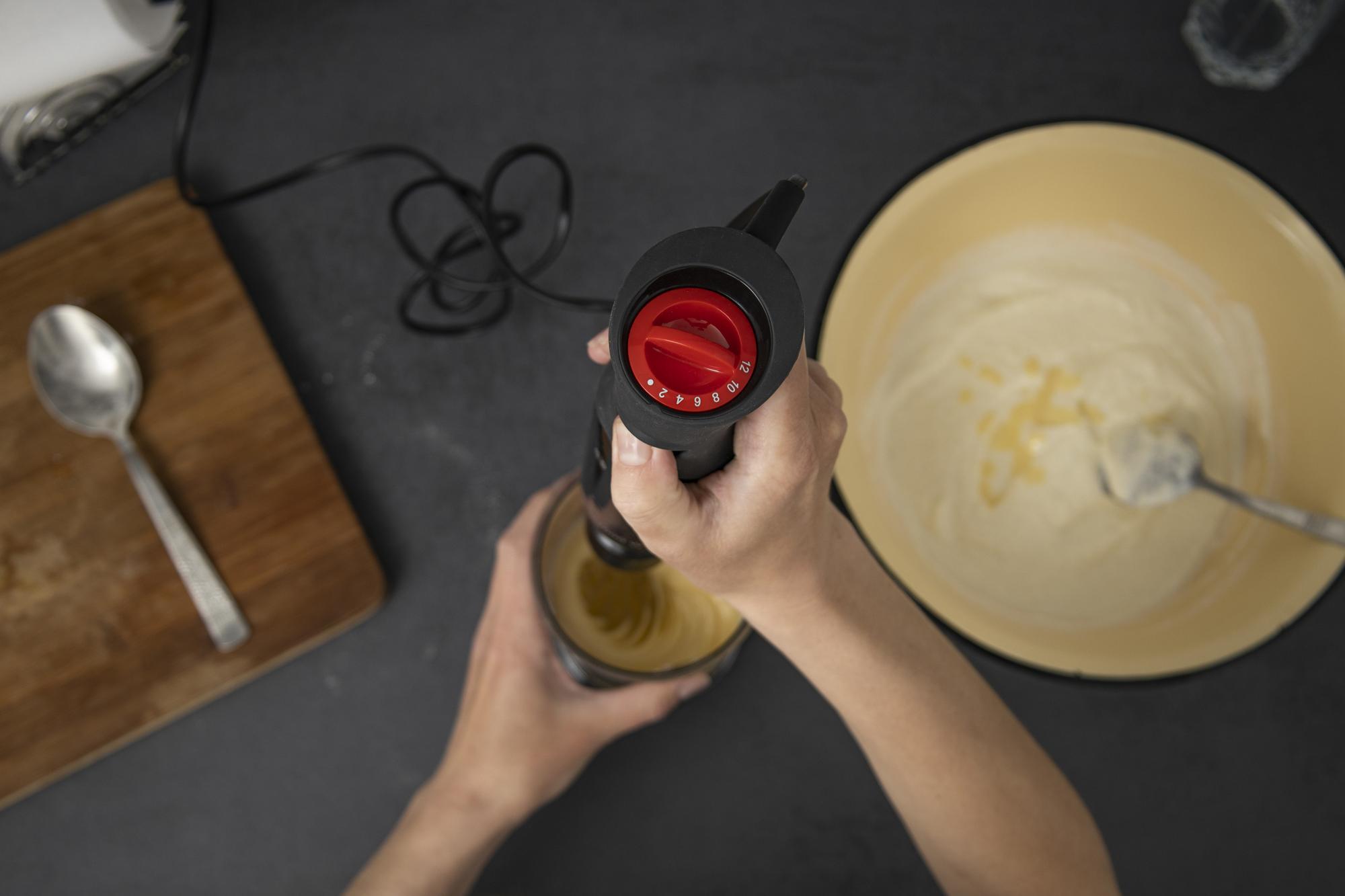 Hand pouring sauce into bowl with care